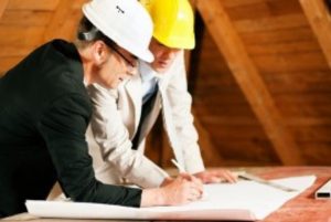 quantity-surveyor-two-men-hardhats-writing-min