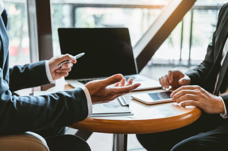 quantity-surveyor-two-men-meeting-hands-laptop